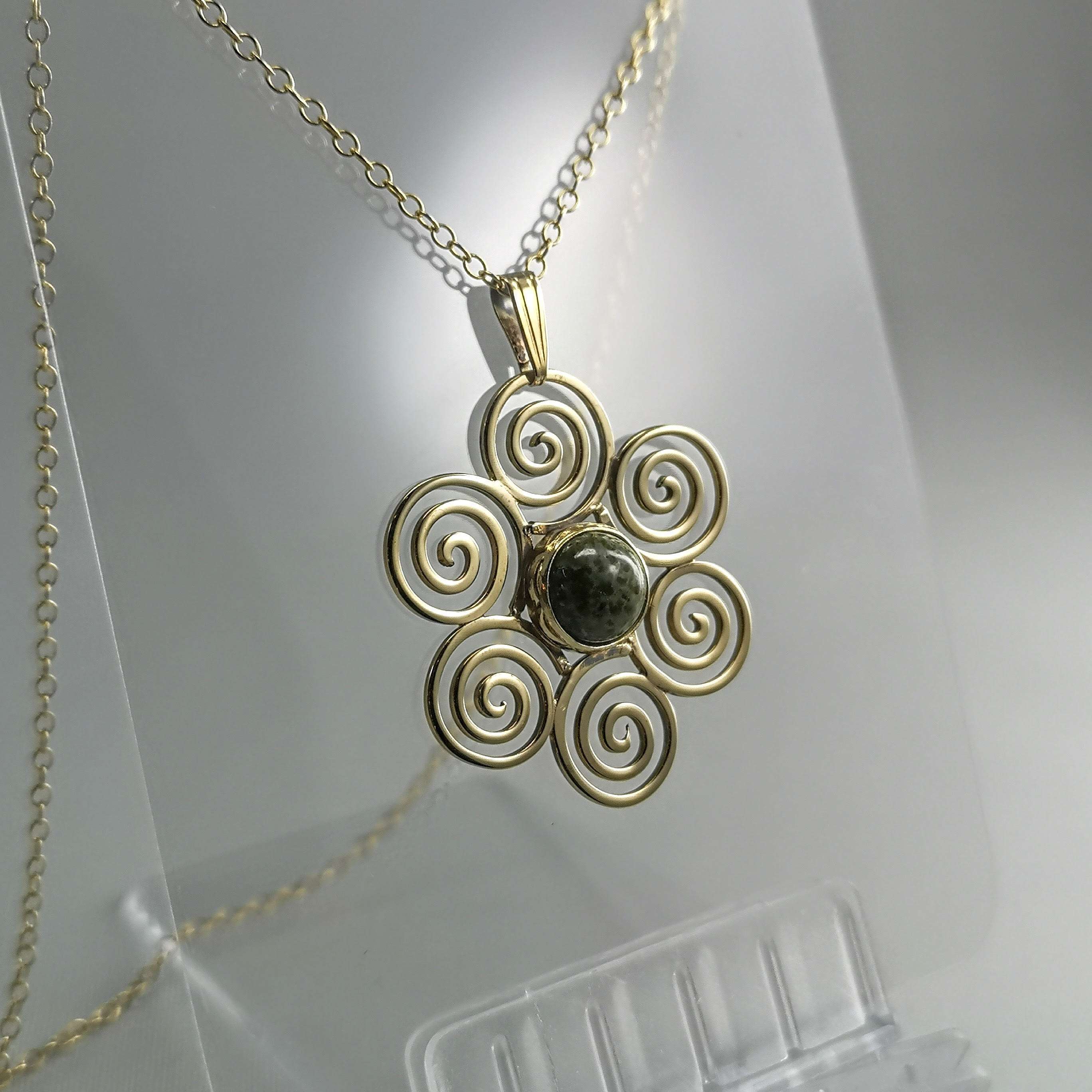 9ct Gold large pendant with a green marble stone surrounded with classic spiral designs and with 18" chain.